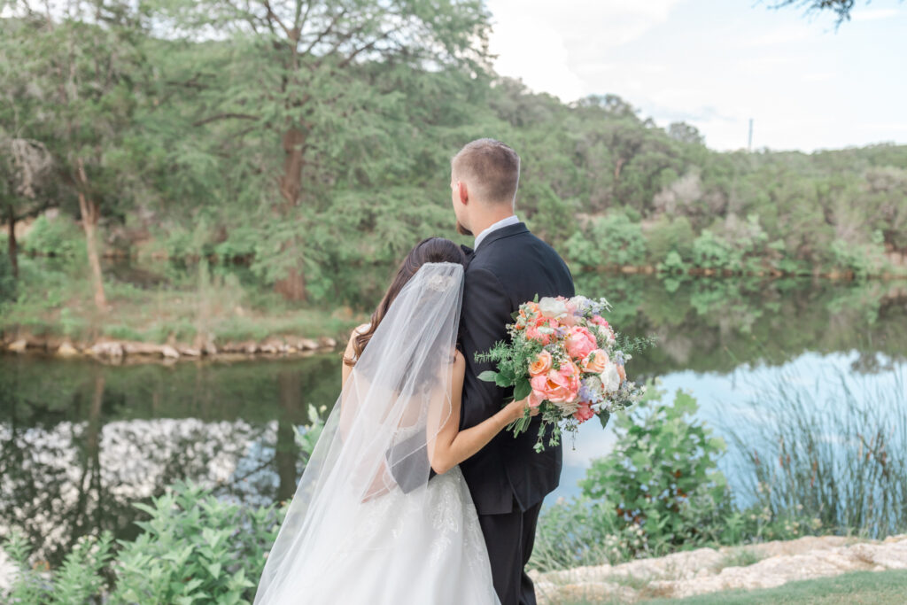 bride and groom looking at lake