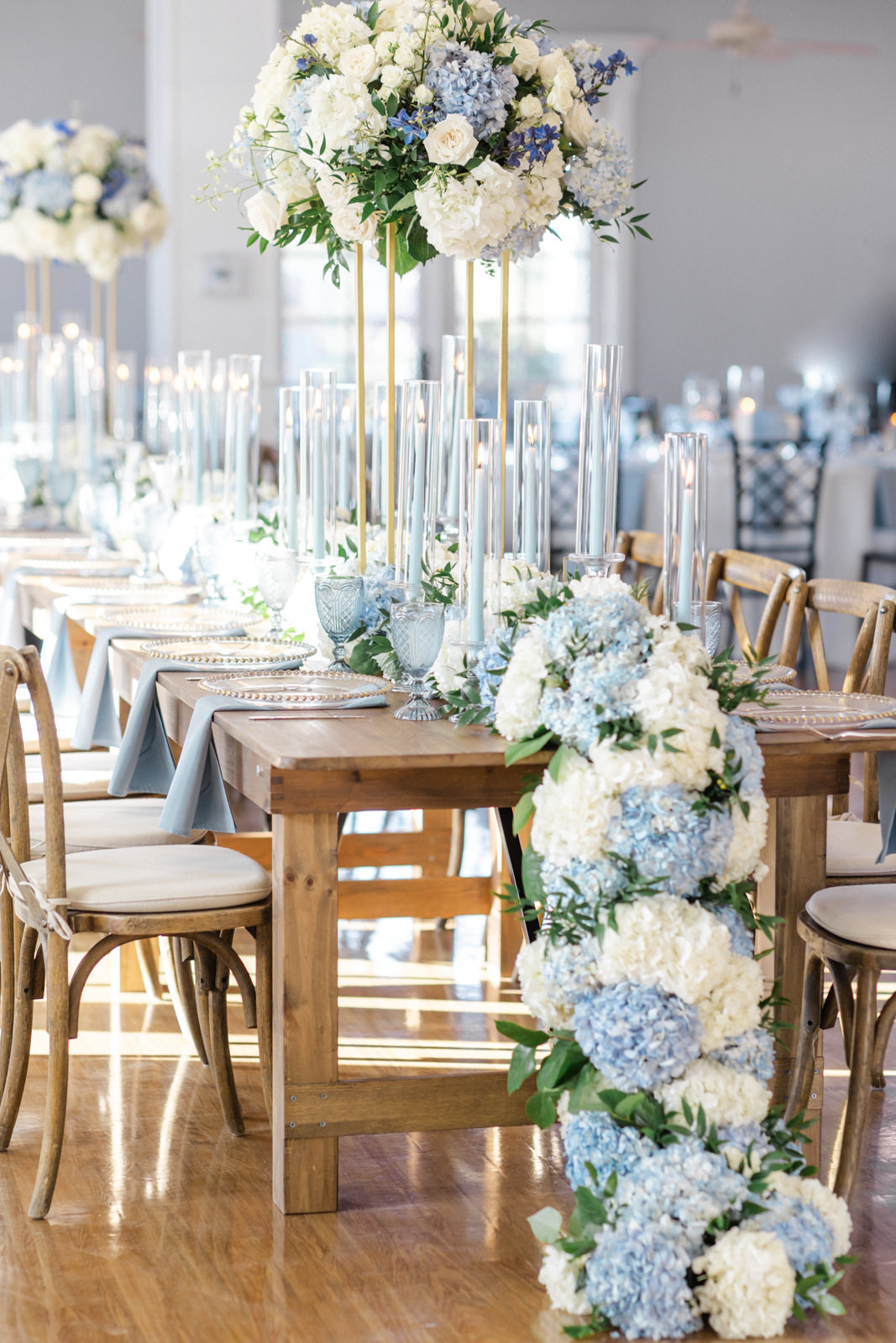 wedding head table with stunning white and blue hydrangea table runner trailing to the ground