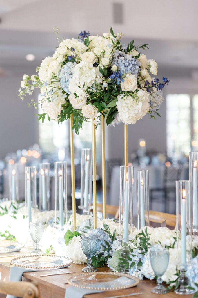 wedding head table with stunning white and blue hydrangea centerpieces and dusty blue candles