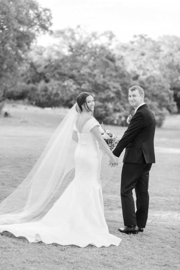 black and white portrait of bride and groom walking