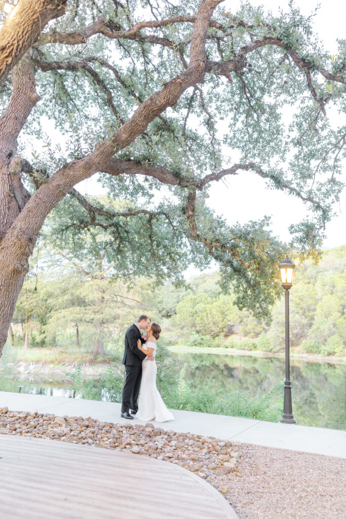 bride and groom kissing under oak tree
