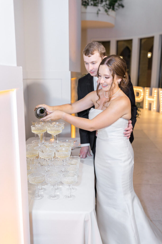 Bride and groom pouring champagne into champagne tower