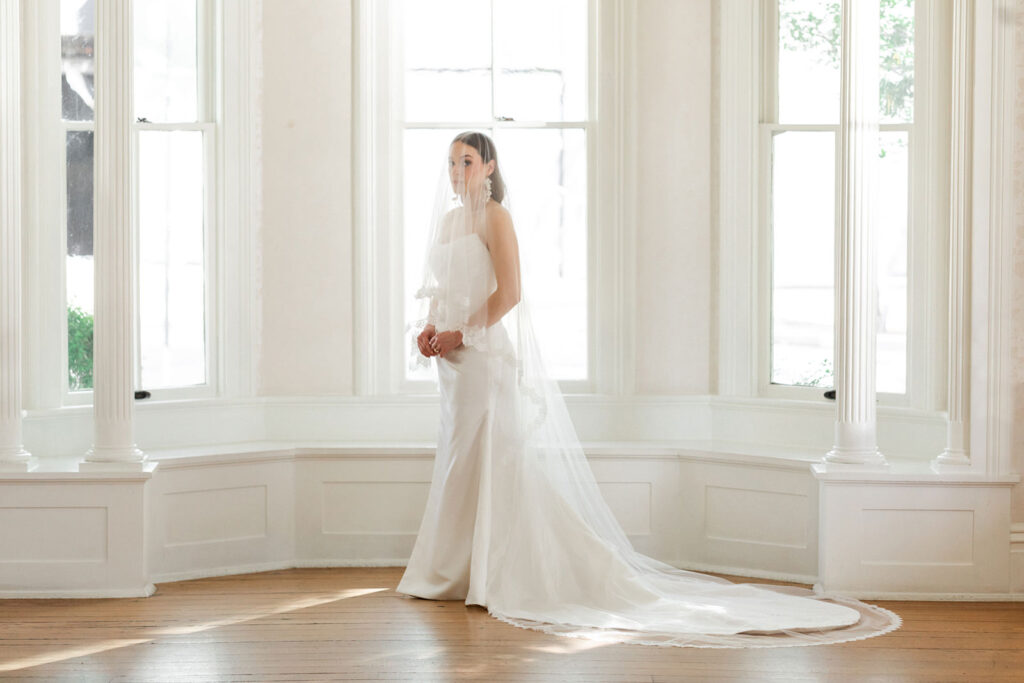 Bride in front of the windows inside the Allan House 