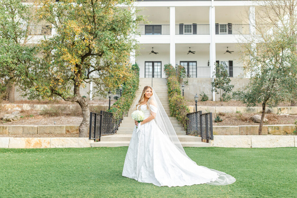 Bride smiling to the right with Kendall Point wedding venue in the background
