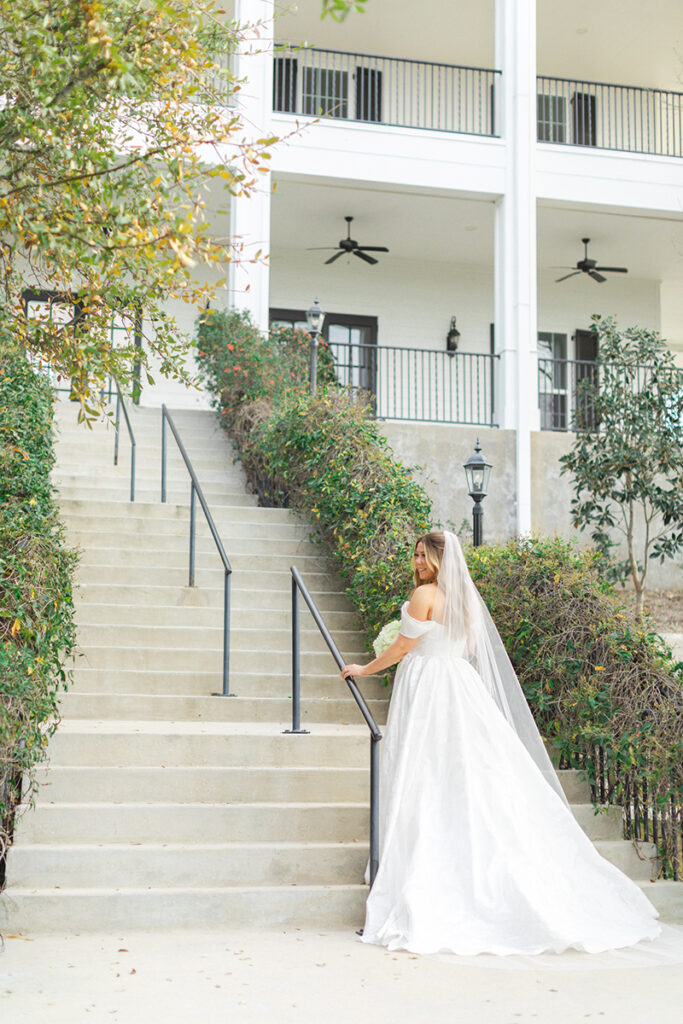 Bride going up back stairs of Kendall Point wedding venue