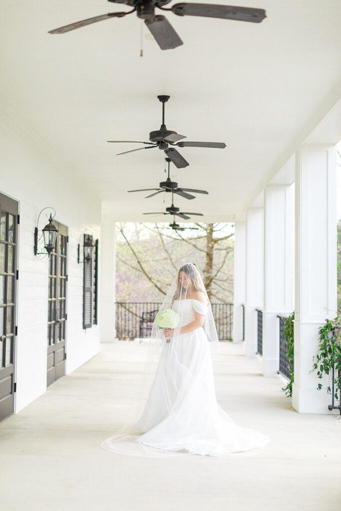 Bride under veil on the Kendall Point wedding venue porch