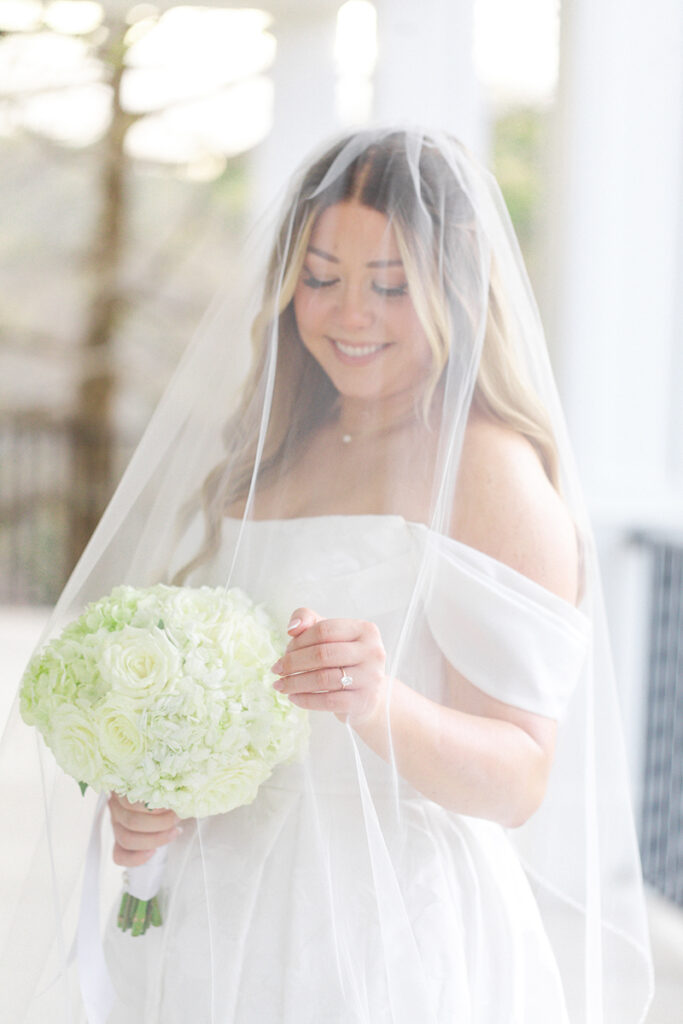 Bride adjusting veil on the Kendall Point wedding venue porch
